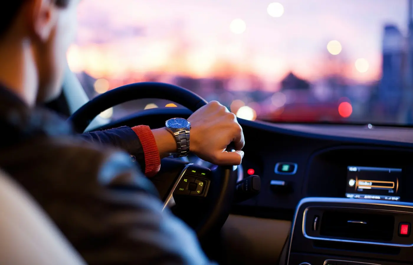 Conducteur au volant, vu de l’habitacle, sur une route