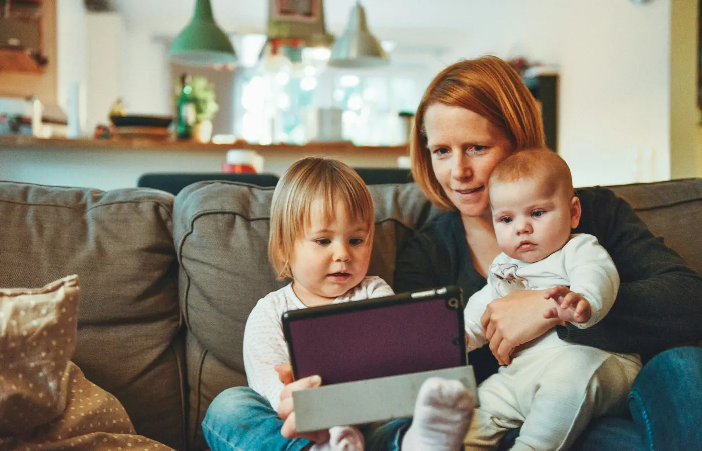 Parent et deux jeunes enfants ensemble sur un canapé